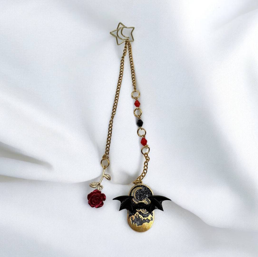 ACOTAR bookmark with a gold chain, Velaris-inspired charm, bat wings, red rose, and moon clip on a white background.