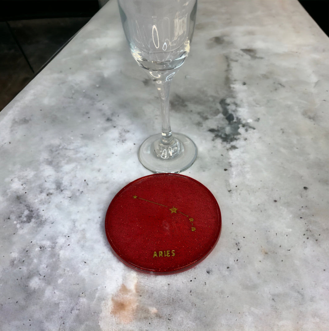 Aries zodiac coaster on marble surface with glass