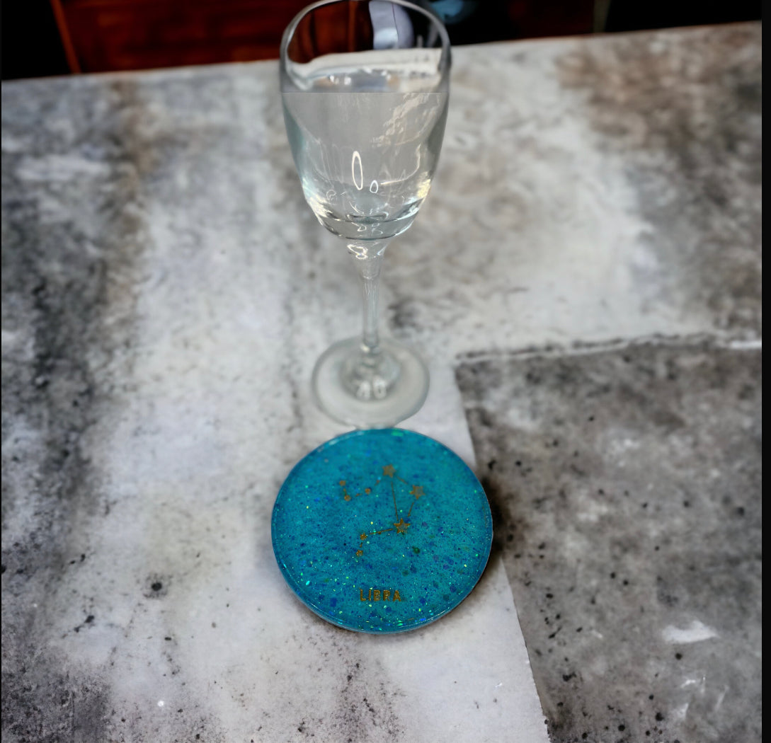 Libra Zodiac Coaster next to a wine glass on a marble surface