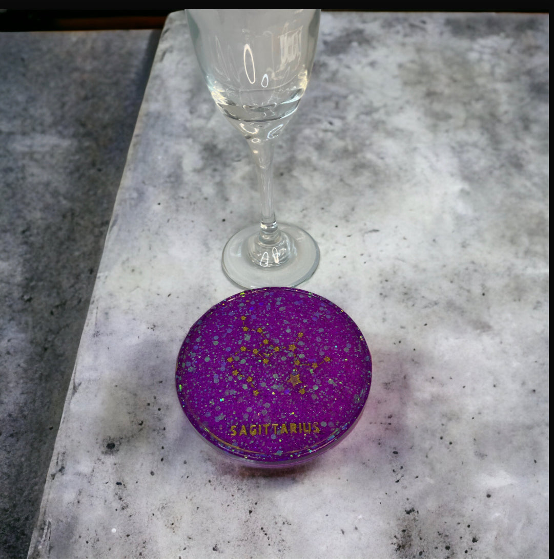 Stylish Sagittarius coaster with glass on marble surface